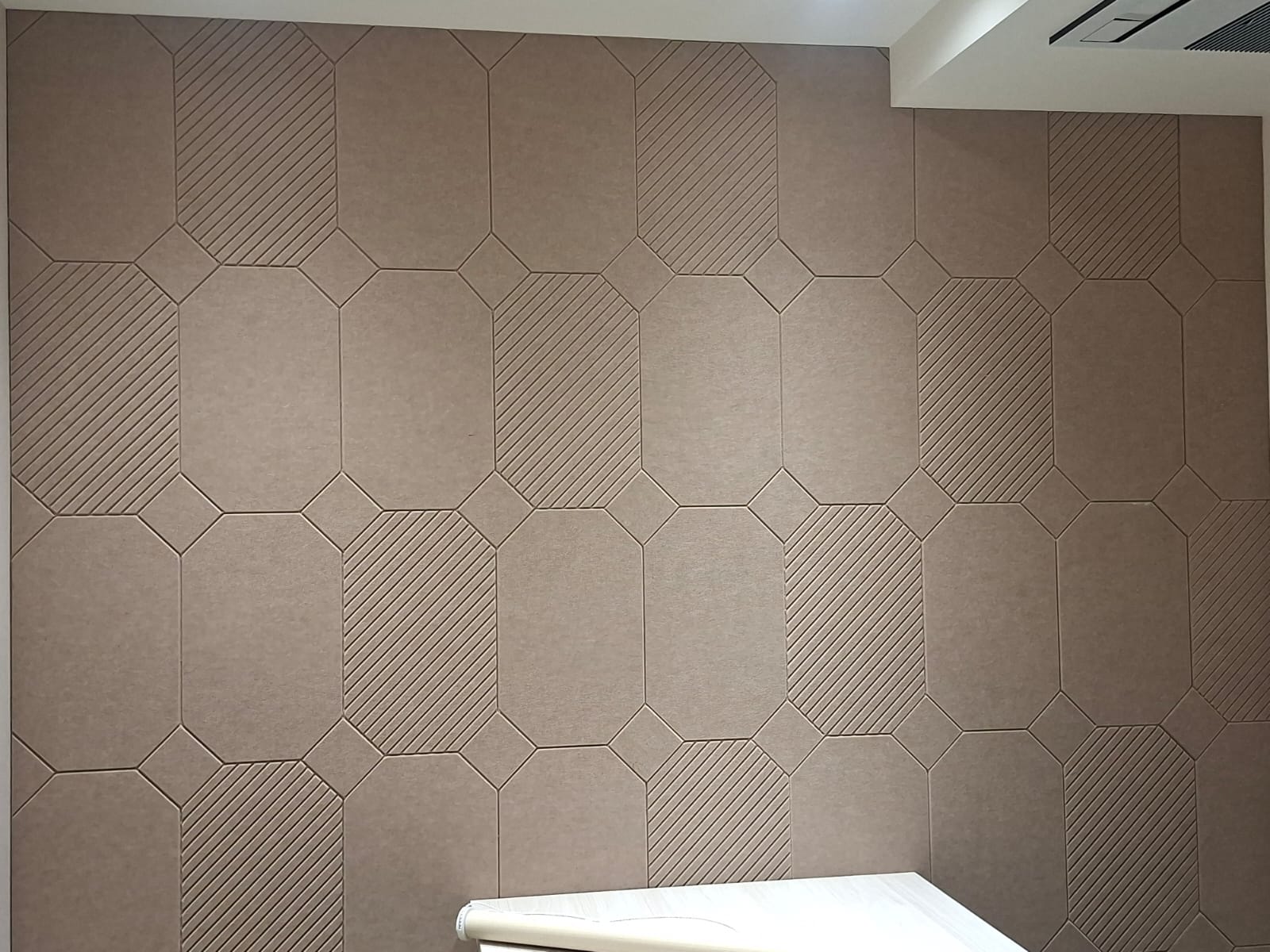Completed beige acoustic wall with repeating geometric panel pattern